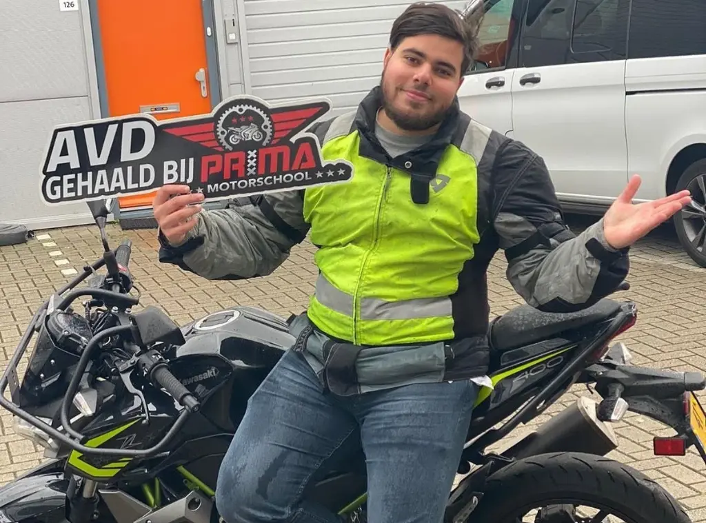 Leerling naast de motor na het geslaagde motorexamen